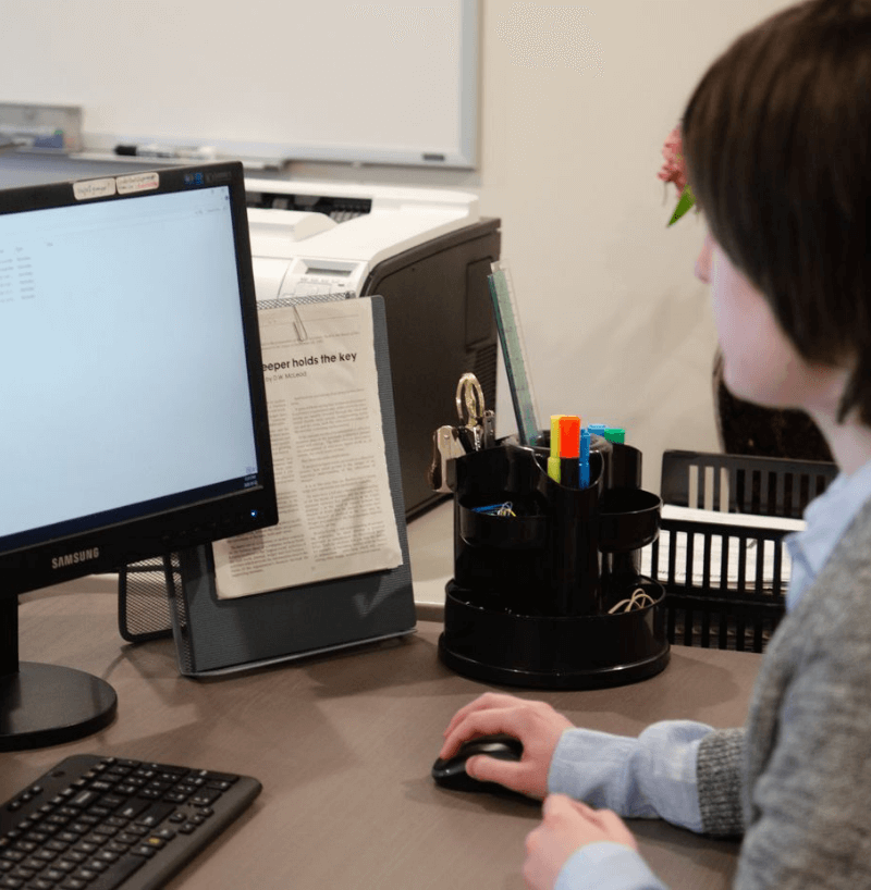 accounting-1 Person looking at a computer screen displaying financial information, representing digital bookkeeping and financial management.